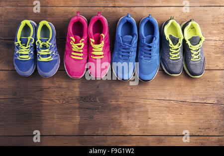 Vier Paare verschiedene Laufschuhe auf einen Holzboden-Hintergrund gelegt Stockfoto