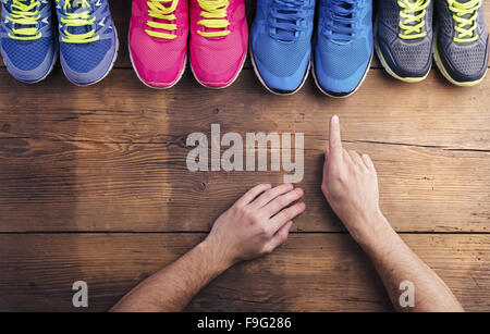 Vier Paare verschiedene Laufschuhe auf einen Holzboden-Hintergrund gelegt Stockfoto