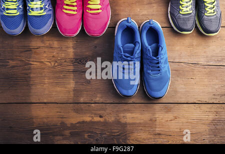 Vier Paare verschiedene Laufschuhe auf einen Holzboden-Hintergrund gelegt Stockfoto