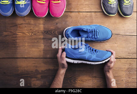 Vier Paare verschiedene Laufschuhe auf einen Holzboden-Hintergrund gelegt Stockfoto