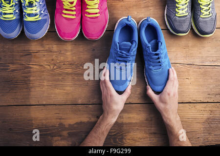 Vier Paare verschiedene Laufschuhe auf einen Holzboden-Hintergrund gelegt Stockfoto