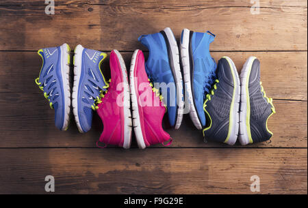 Vier Paare verschiedene Laufschuhe auf einen Holzboden-Hintergrund gelegt Stockfoto