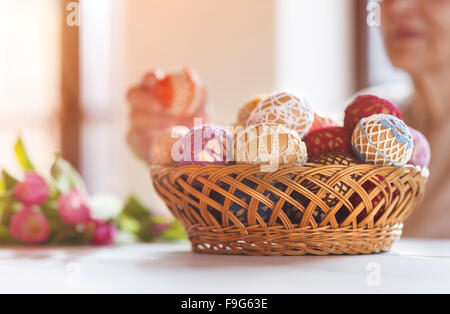 Nicht erkennbare senior Frau mit Ostereiern und Tulpen. Stockfoto