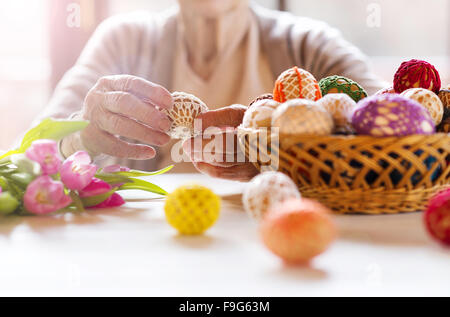 Nicht erkennbare senior Frau mit Ostereiern und Tulpen. Stockfoto