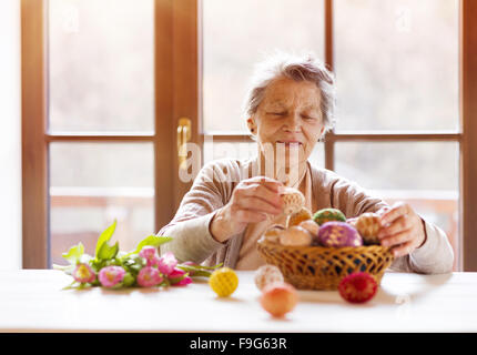 Schöne ältere Frau mit Ostereier und Tulpen. Stockfoto