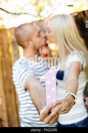 Glückliches junges Paar in Liebe umarmen und küssen außerhalb neben der Holzzaun Stockfoto