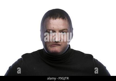 Dieb in Balaclava lustige Grimassen, in schwarz gekleidet. Studio auf weißem Hintergrund gedreht. Stockfoto