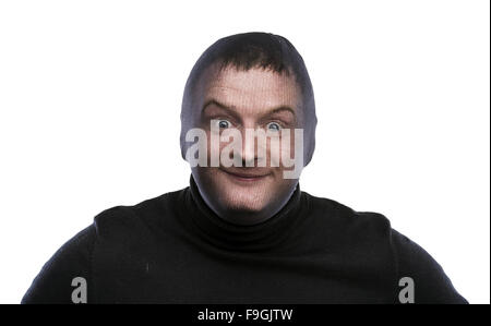 Dieb in Balaclava lustige Grimassen, in schwarz gekleidet. Studio auf weißem Hintergrund gedreht. Stockfoto