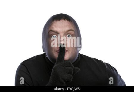 Dieb in Balaclava lustige Grimassen, in schwarz gekleidet. Studio auf weißem Hintergrund gedreht. Stockfoto