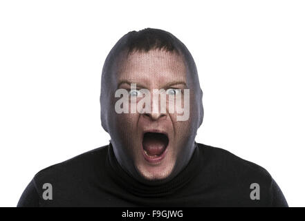 Dieb in Balaclava lustige Grimassen, in schwarz gekleidet. Studio auf weißem Hintergrund gedreht. Stockfoto