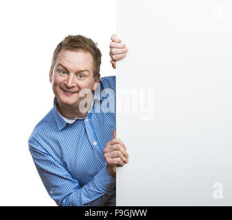 Junger Mann, lustiges Gesicht macht, hält ein leeres Schild. Studio auf weißem Hintergrund gedreht. Stockfoto