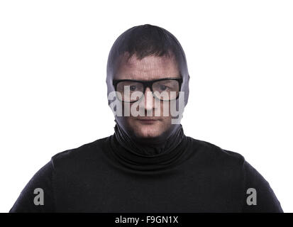 Dieb in Balaclava lustige Grimassen, in schwarz gekleidet. Studio auf weißem Hintergrund gedreht. Stockfoto