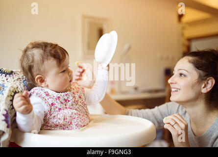 Junge Mutter und ihrer kleinen Tochter zusammen frühstücken Stockfoto