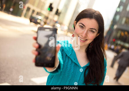 junge Frau zeigt der Bildschirm von ihr Telefon Stockfoto