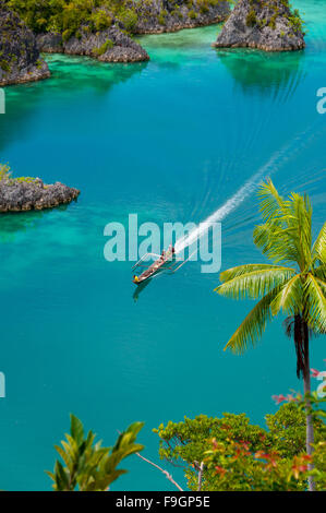 Boot Kreuzfahrt rund um kleine grüne Inseln gehören zu Fam-Insel im Meer von Raja Ampat, Papua-Neu-Guinea Stockfoto