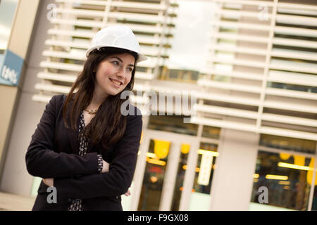 junge Frau trägt einen Schutzhelm Bau mit einem Architektur-Hintergrund Stockfoto