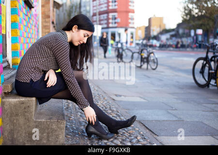 junge Frau in der Straße Gefühl Schmerz im Knöchel Stockfoto