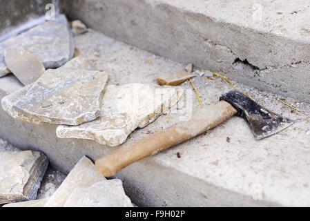 Nahaufnahme von einer alten Axt und Steinplatten gelegt auf Treppe Stockfoto