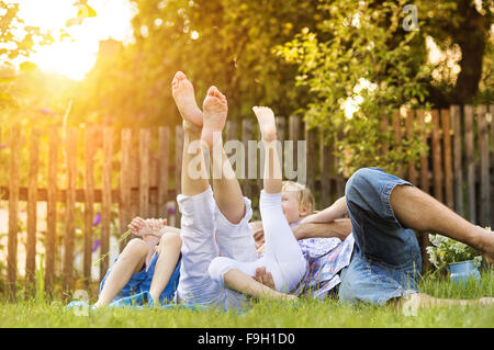 Glückliche junge Familie zeigt Beine draußen in der grünen Natur. Stockfoto