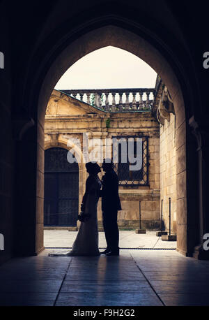 Genießen Sie romantische Momente vor einem Schloss junge Hochzeitspaar Stockfoto