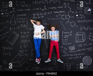 Netten jungen und Mädchen lernen spielerisch im Frot an einer großen Tafel Stockfoto