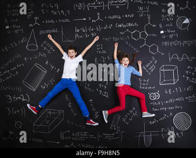 Netten jungen und Mädchen lernen spielerisch im Frot an einer großen Tafel Stockfoto