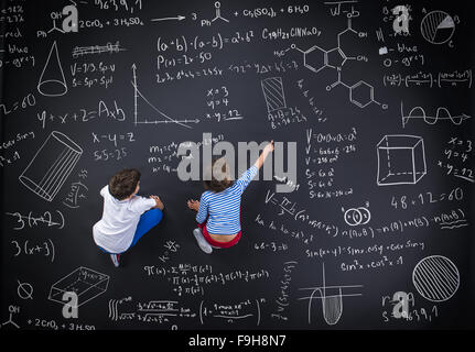 Netten jungen und Mädchen lernen spielerisch im Frot an einer großen Tafel Stockfoto