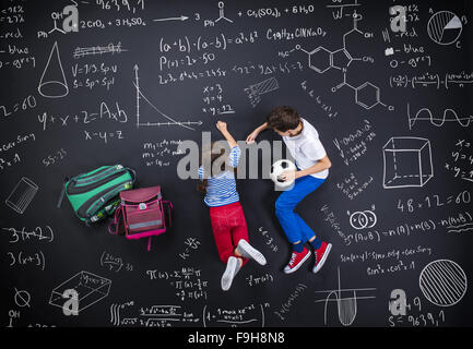 Netten jungen und Mädchen lernen spielerisch im Frot an einer großen Tafel Stockfoto