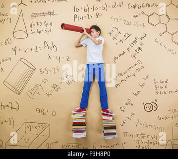 Niedliche kleine Junge lernen spielerisch im Frot an einer großen Tafel. Studio auf Beige Hintergrund gedreht. Stockfoto