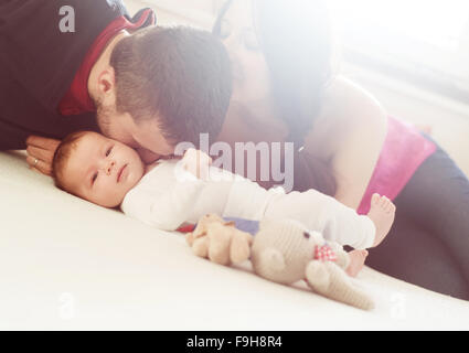 Glückliche junge Eltern mit ihren kleinen Baby Mädchen zu Hause Stockfoto