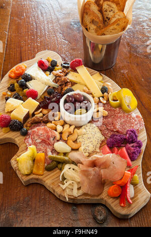 Schwein-förmigen Wurstwaren Board mit Käse, Fleisch, eingelegtes Gemüse, Marmelade, Nüssen, Obst, Oliven und Crostini, saftigen Cafe Stockfoto