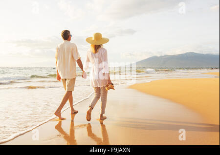 Glückliche romantische mittleren gealterten paar schönen Sonnenuntergang genießen Fuß am Strand. Reisen-Urlaub-Ruhestand-Lifestyle-Konzept Stockfoto