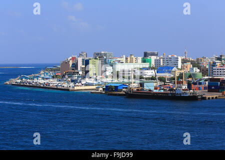 Containerhafen an der dicht besiedelten Insel Male auf den Malediven, Indischer Ozean, wie aus einem vorbeifahrenden Kreuzfahrtschiffen. Stockfoto