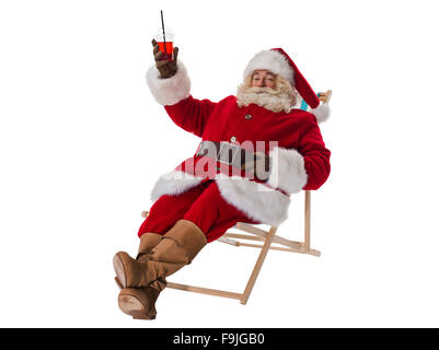 Weihnachtsmann auf Liegestuhl sitzen und trinken cocktail voller Länge Portrait isoliert auf weißem Hintergrund Stockfoto