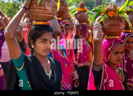 Indische Frauen, die Angebote auf ihren Köpfen während eines Festes von Rajasthan, Pushkar, Indien Stockfoto