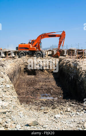 Bagger befindet sich am Rande der Grube, die sie gegraben Stockfoto