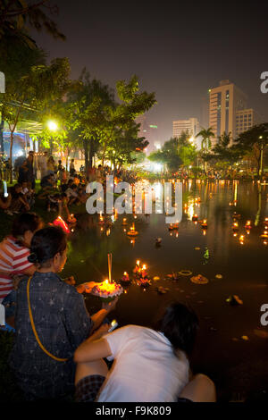 Thais starten Krathongs mit brennenden Kerzen in Wasser in die Innenstadt von Lumpini-Park-See während der Betriebsferien Thai Festival Loi Stockfoto