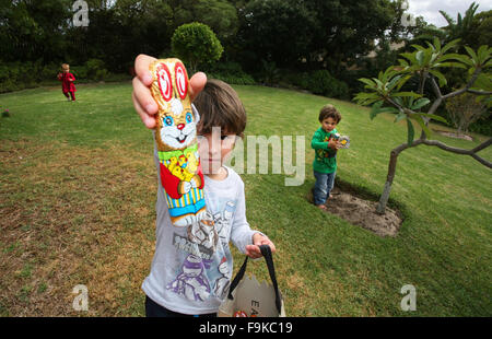 Junge Kinder sammeln Ostereier auf eine Oster-Jagd in einem Garten. Stockfoto