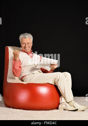 Reifer Mann sitzend Stockfoto