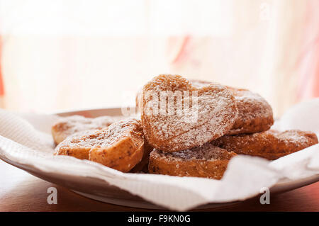 Frisch gebackene leckere Cookies auf einem Teller in Herzform Stockfoto