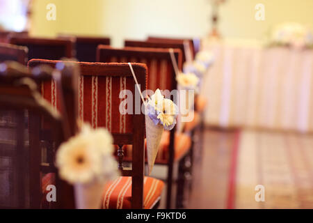 Blumendekoration auf Stühlen auf Hochzeit Stockfoto