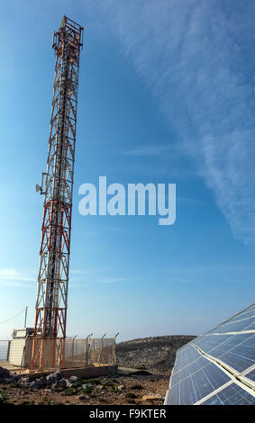 Sonnenkollektoren und Handy-Mast gegen blauen Himmel Stockfoto