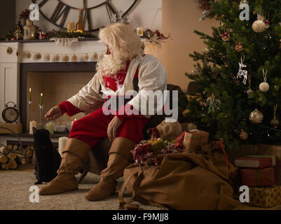 Santa Claus zu Hause mit seiner Katze Stockfoto