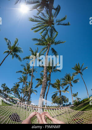 Einen weiten Winkel fisheye Blick auf ein junges Paar Füße in einer Hängematte auf dem Gelände der Fairmont Orchid, Kohala Coast, Hawai ' i. Stockfoto