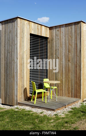 Wohnothek Pensionen in den Weinbergen, Deutsch-Schuetzen, Burgenland, Österreich. Holzwänden und kleine Terrasse mit Tisch und Stühlen. Stockfoto