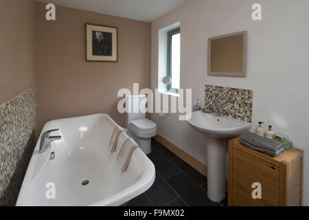 Familienbad in einem Moder-Haus mit traditionellen Badewanne, Waschbecken und Toilette. Stockfoto