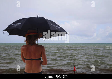 Playa Del Carmen, Mexiko. 17. Dezember 2015. Eine Frau Tierheime vor dem Regen von als Klima ändern zeigt sich in Playa Del Carmen, Mexiko. Die Regenzeit war wegen Ende Mitte November aber jetzt voraussichtlich in den Januar hinein © Jon Freeman/Alamy News Stockfoto