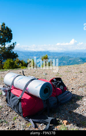 Rot Rucksack mit Isomatte legt auf felsigen Boden vor Berg Tajamulco und blauer Himmel mit Wolken Stockfoto