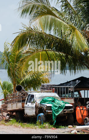 Junk-e-gebrochenen LKW, Papierkorb und Palmen Bäume direkt am Meer mit Sonnenlicht Stockfoto