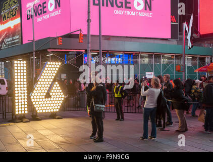 Besucher zum Times Square in New York posieren vor den zwei sieben Fuß hohe Ziffern '1' und '6' auf Dienstag, 15. Dezember 2015.  Die 16 wird "die led-Anzeige oben auf One Times Square, die am 1. Januar Mitternacht Rechtschreibung heraus ' 2016 leuchtet gehören". Die Zahlen verwenden Energie effiziente LED-Lampen, die das ganze Jahr dauern werden, die nie geändert werden.  (© Richard B. Levine) Stockfoto